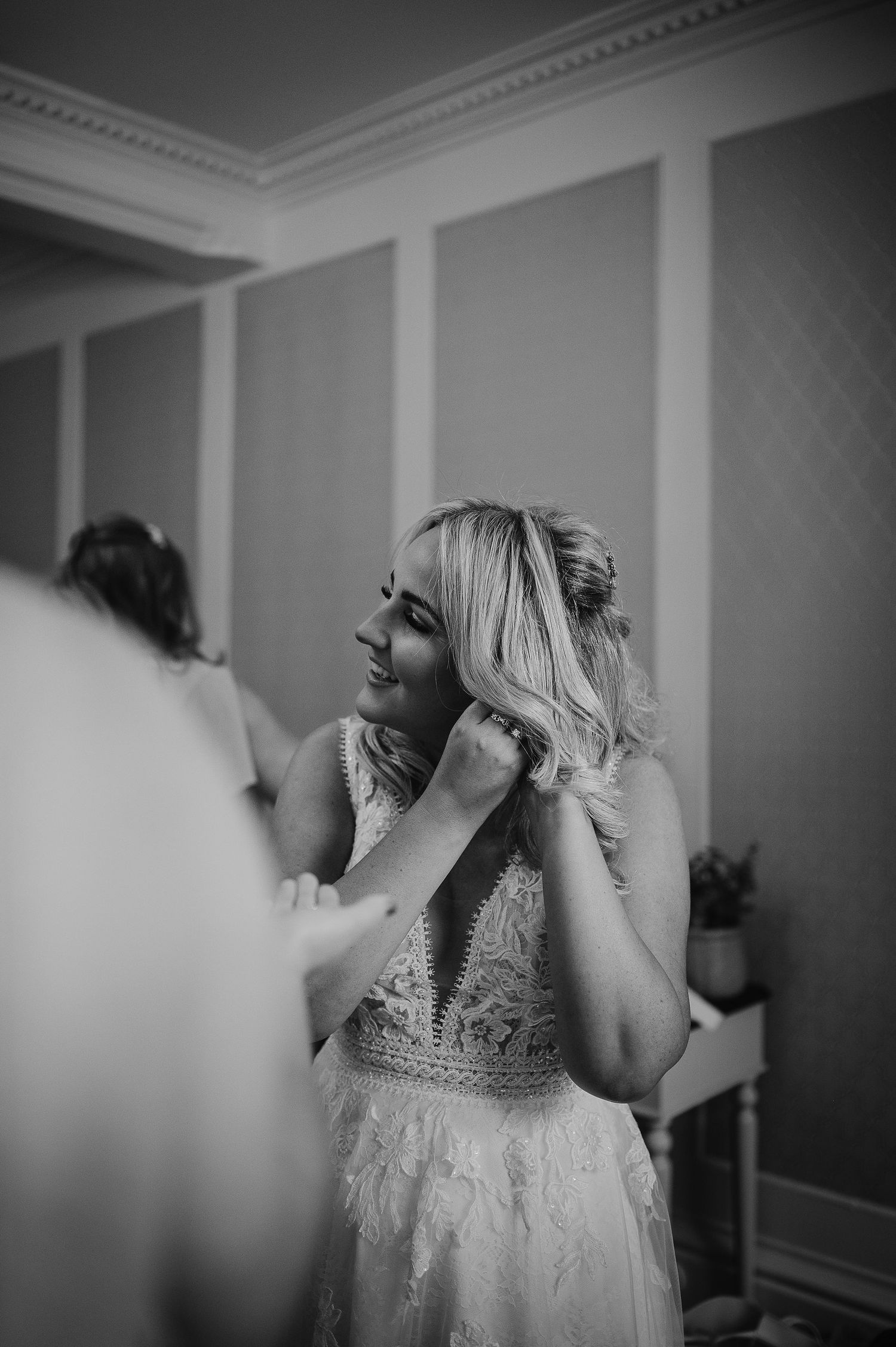 Wedding preparation scene in elegant room with ornate crown molding.
