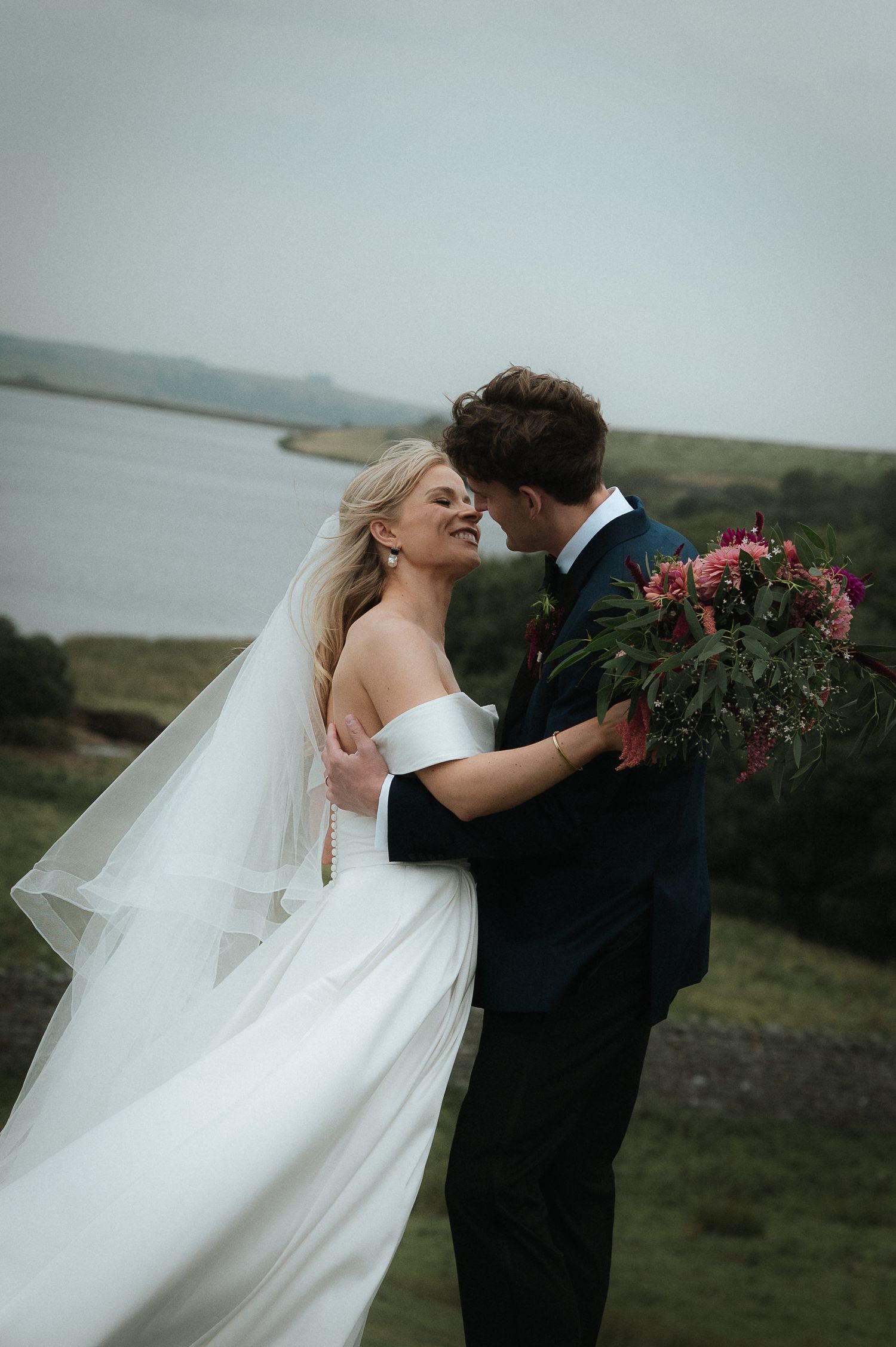 Romantic coastal wedding scene with flowing veil and dramatic cliffside ocean backdrop. Luke Hassall Photography.