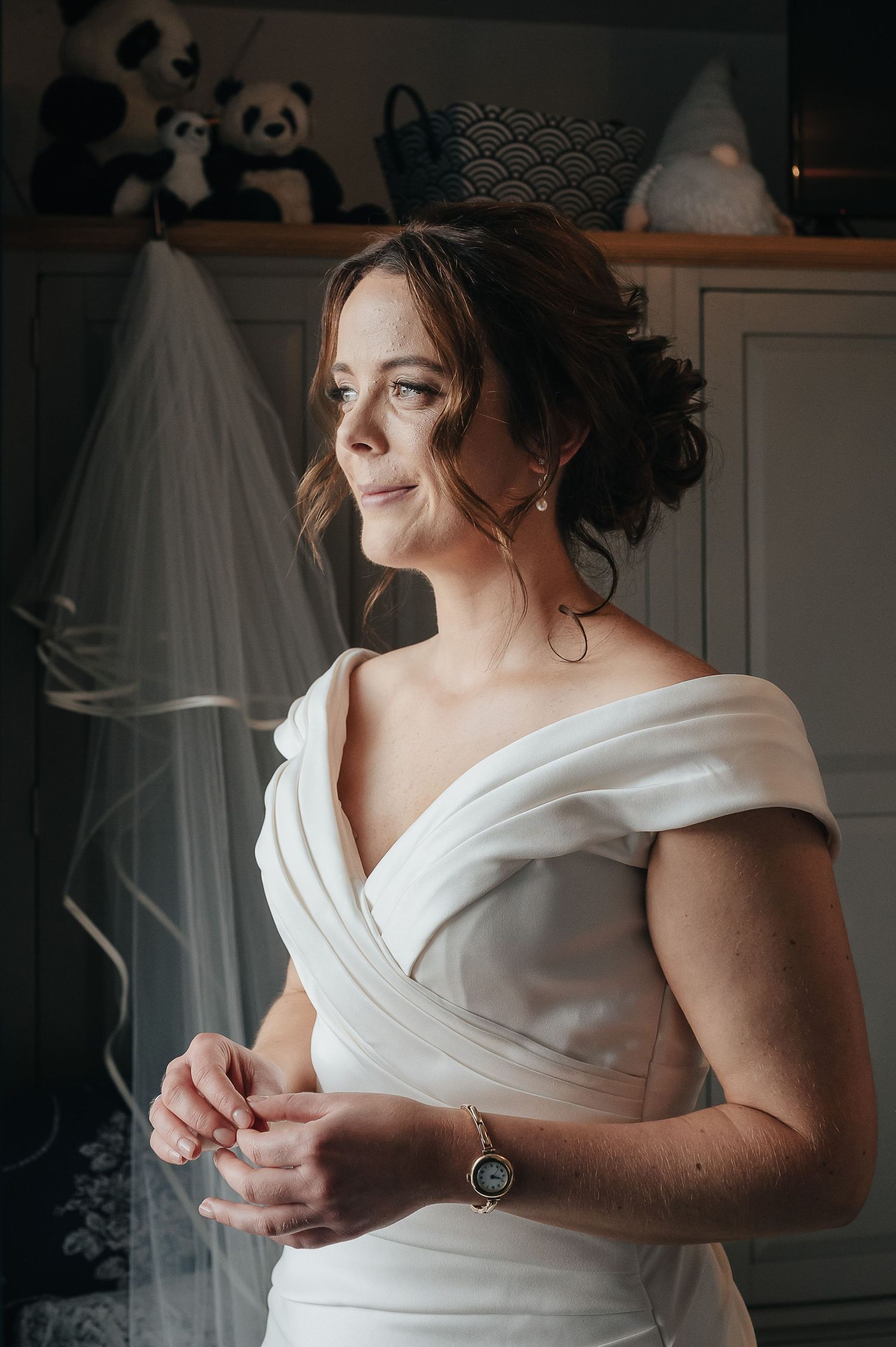 Elegant bridal portrait showing classic white dress with soft window lighting.