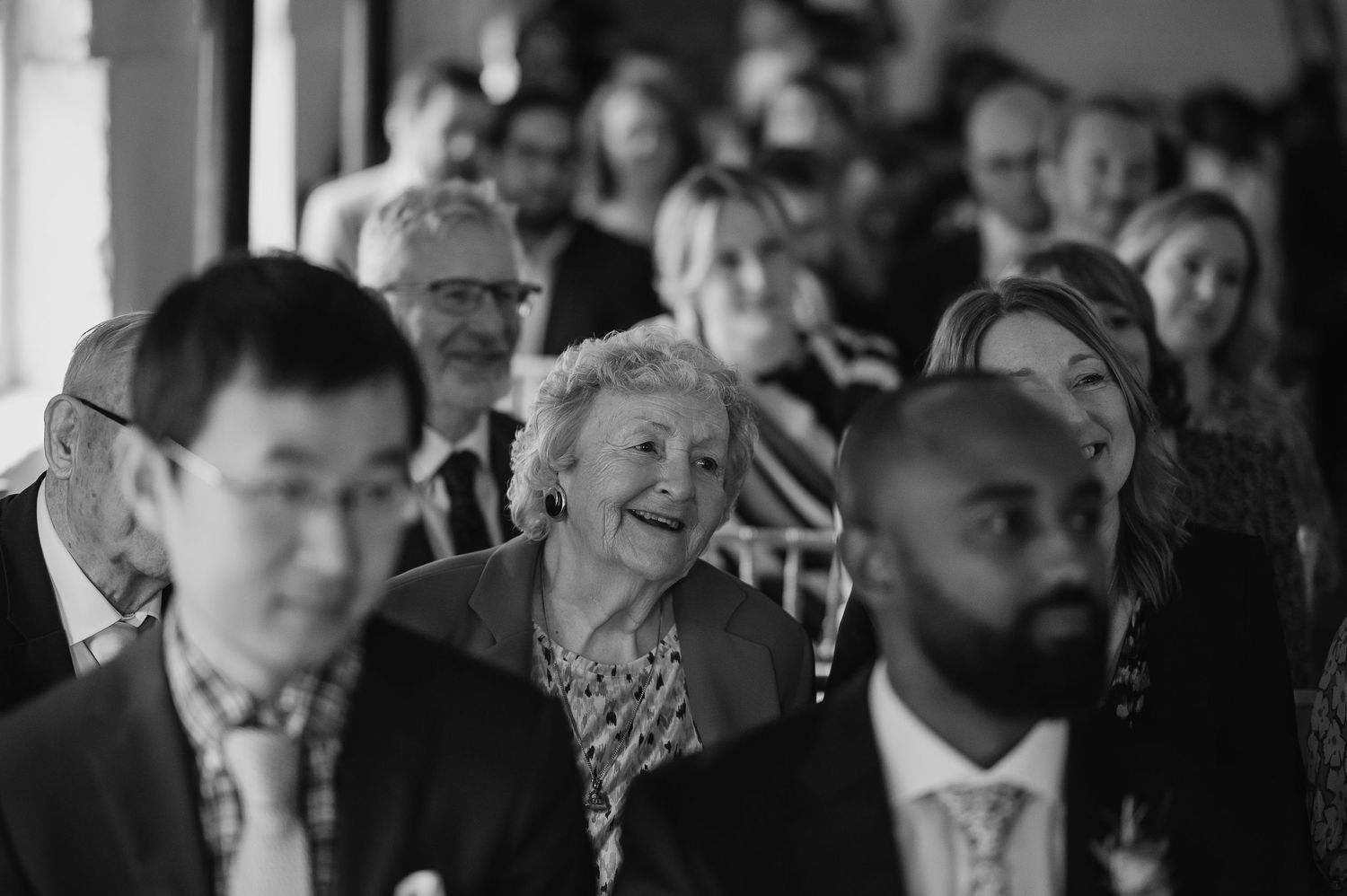 Black and white photo of wedding guests enjoying the celebration.