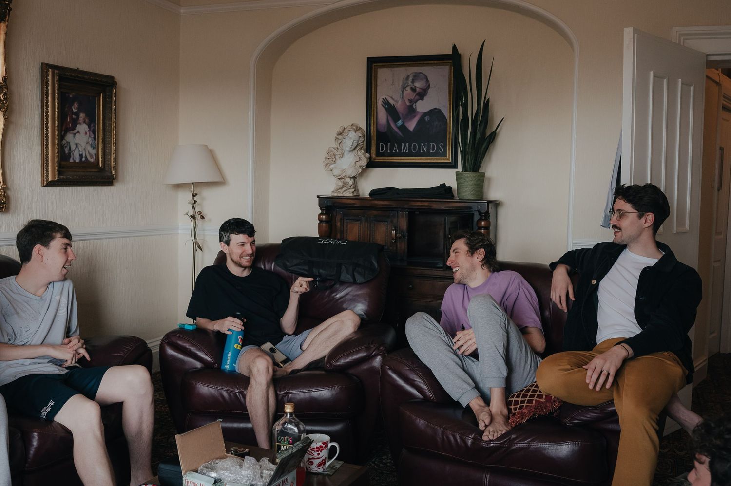 A group of friends relaxing and having a conversation in a cozy living room setting.