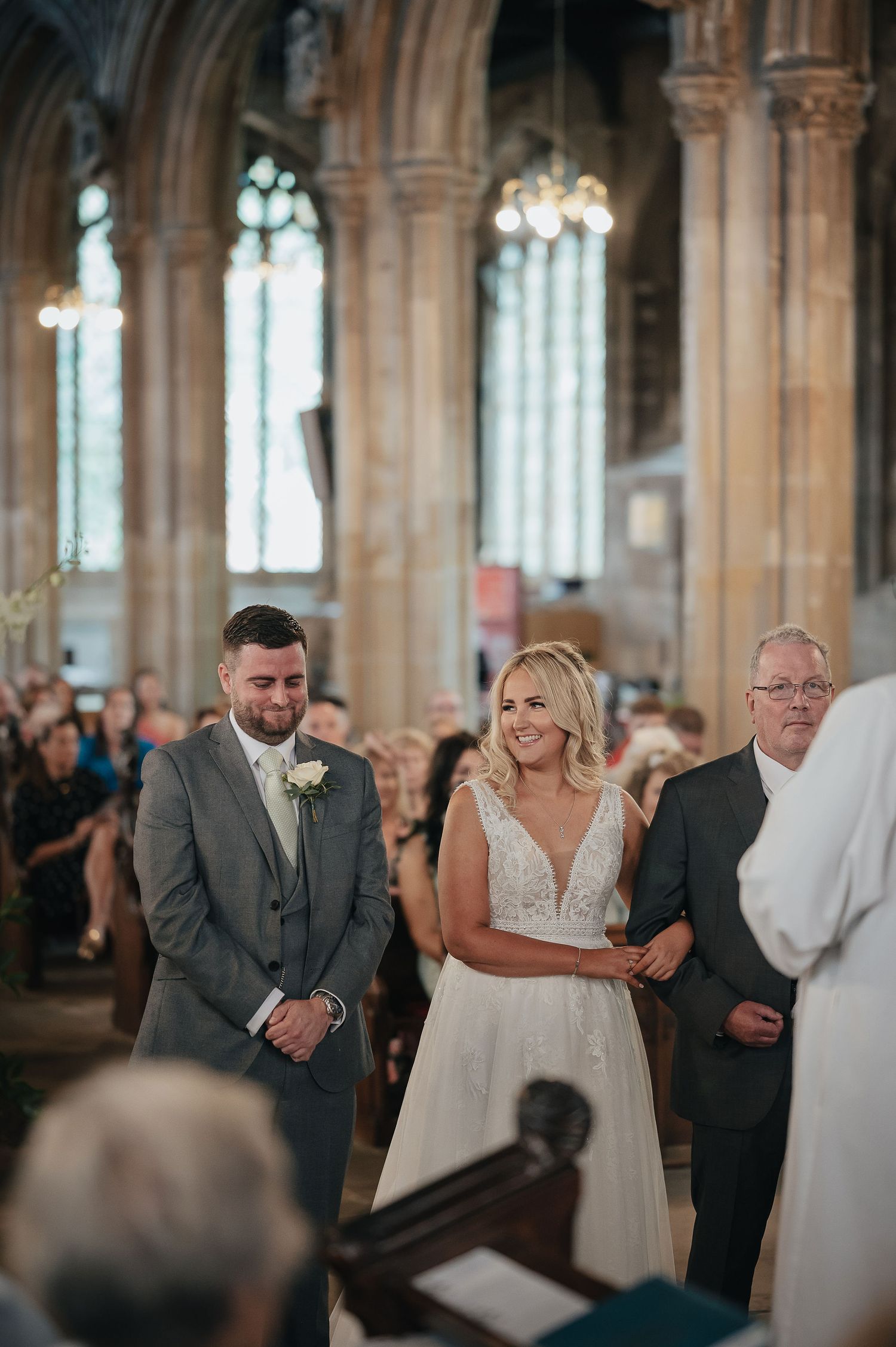 Wedding ceremony taking place in a beautiful historic church with gothic architecture.