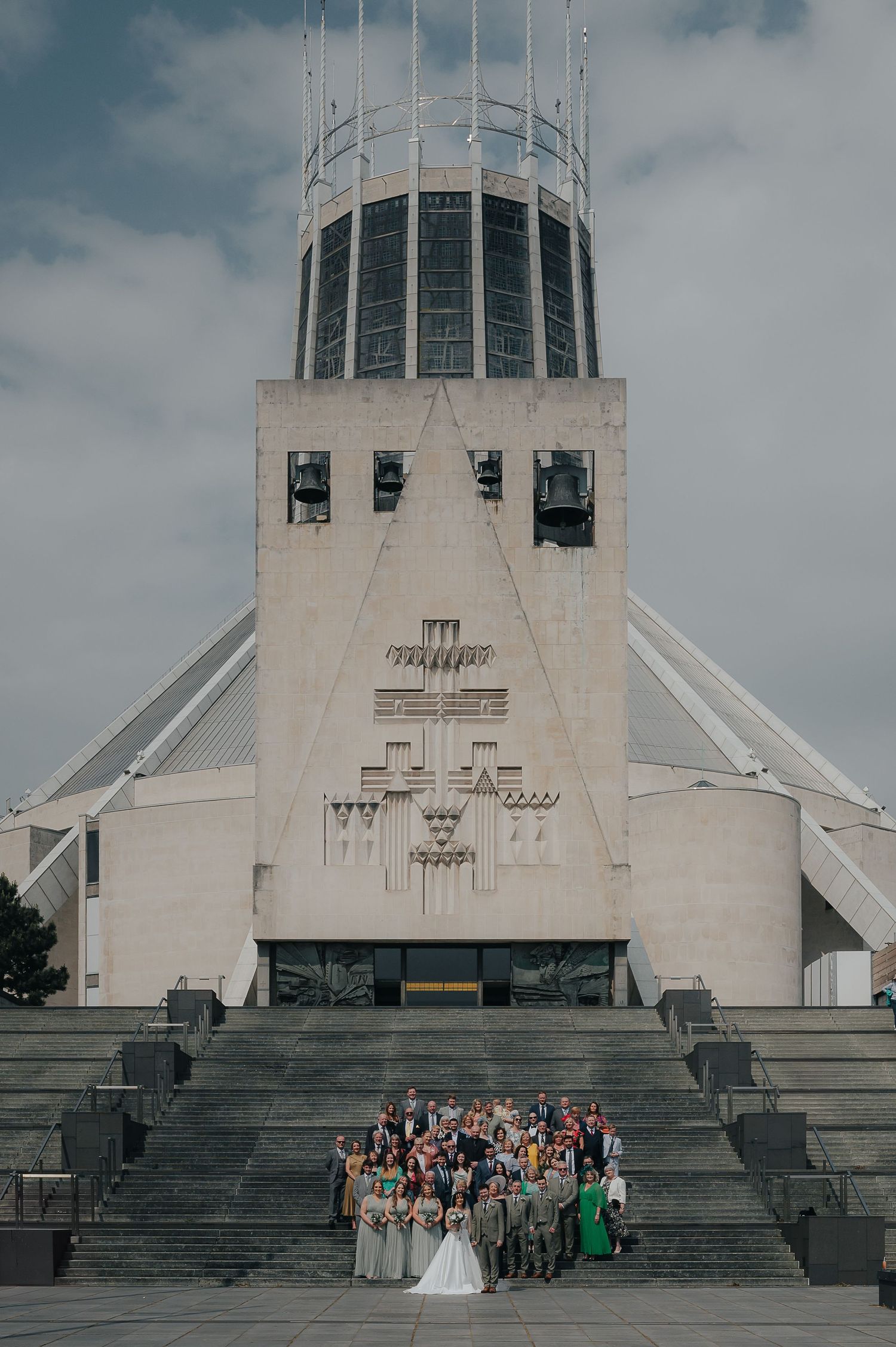 A wedding group photo taken on the steps of Liverpool Metropolitan Cathedral.
