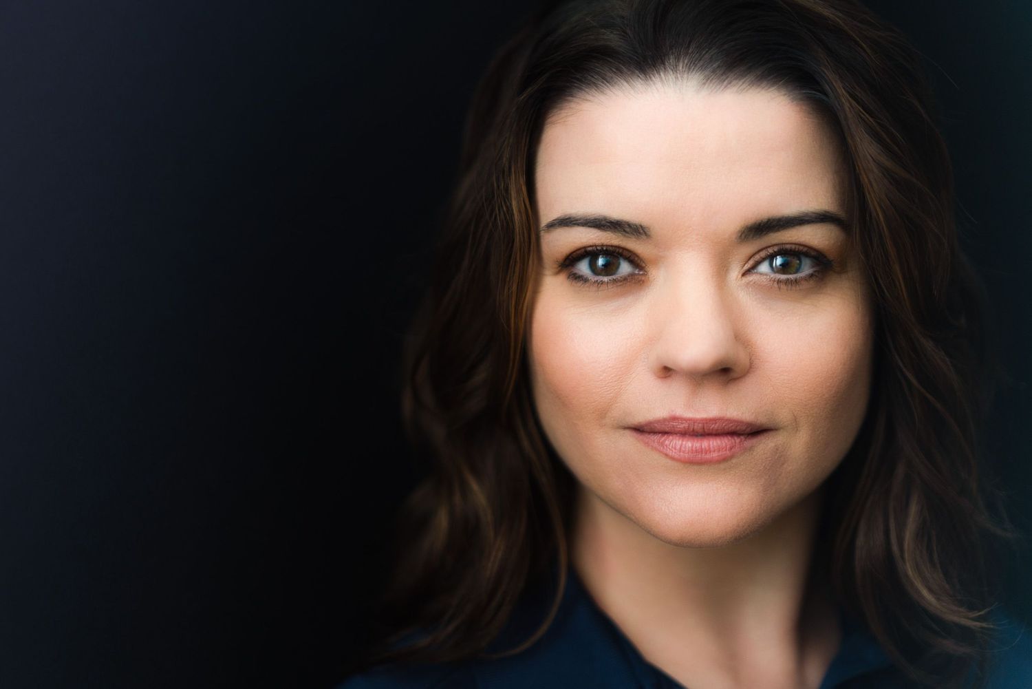 A series of headshots showing the same woman with dark hair in different poses and expressions.