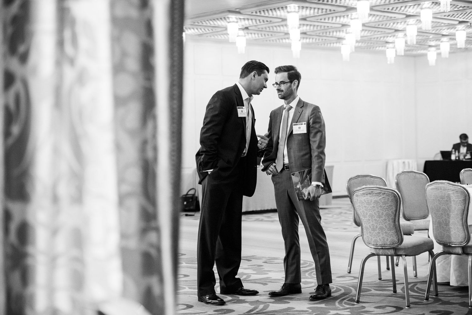 Black and white collage of candid wedding moments showing guests interacting during a formal reception.