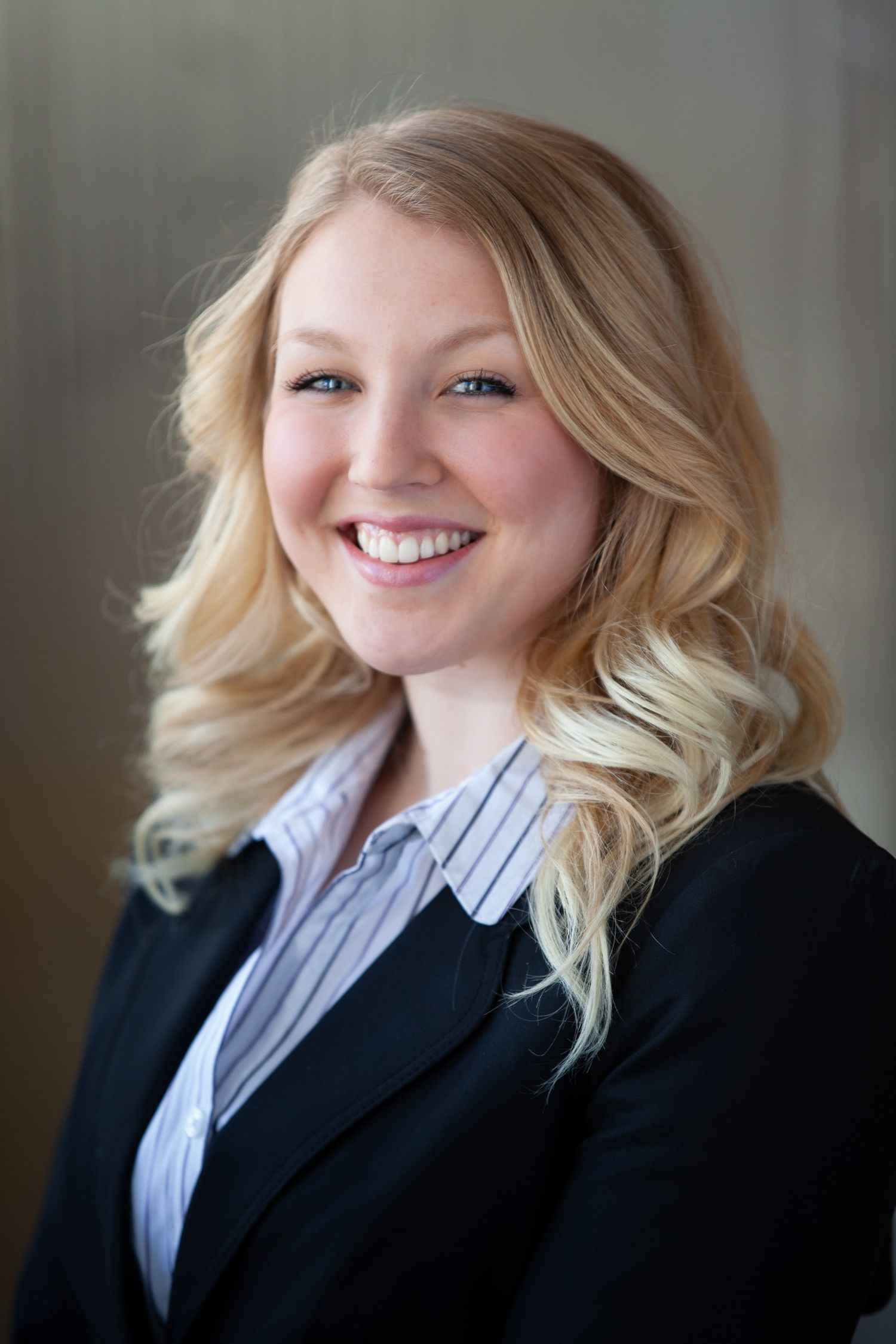 Professional headshot series showing different expressions in business attire against a dark background.