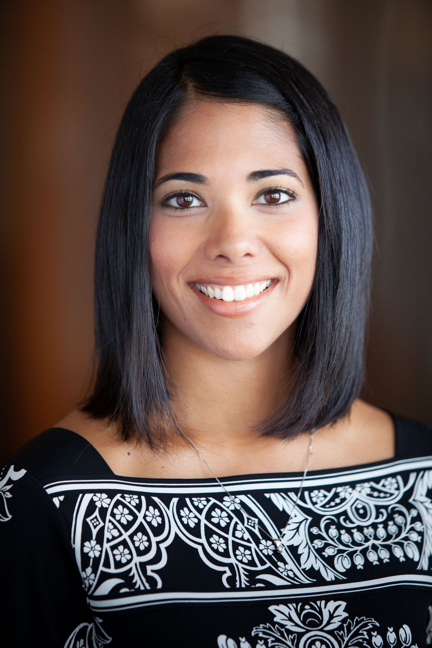 A series of portraits showing a bright smile and black hair against a dark background wearing a patterned top.
