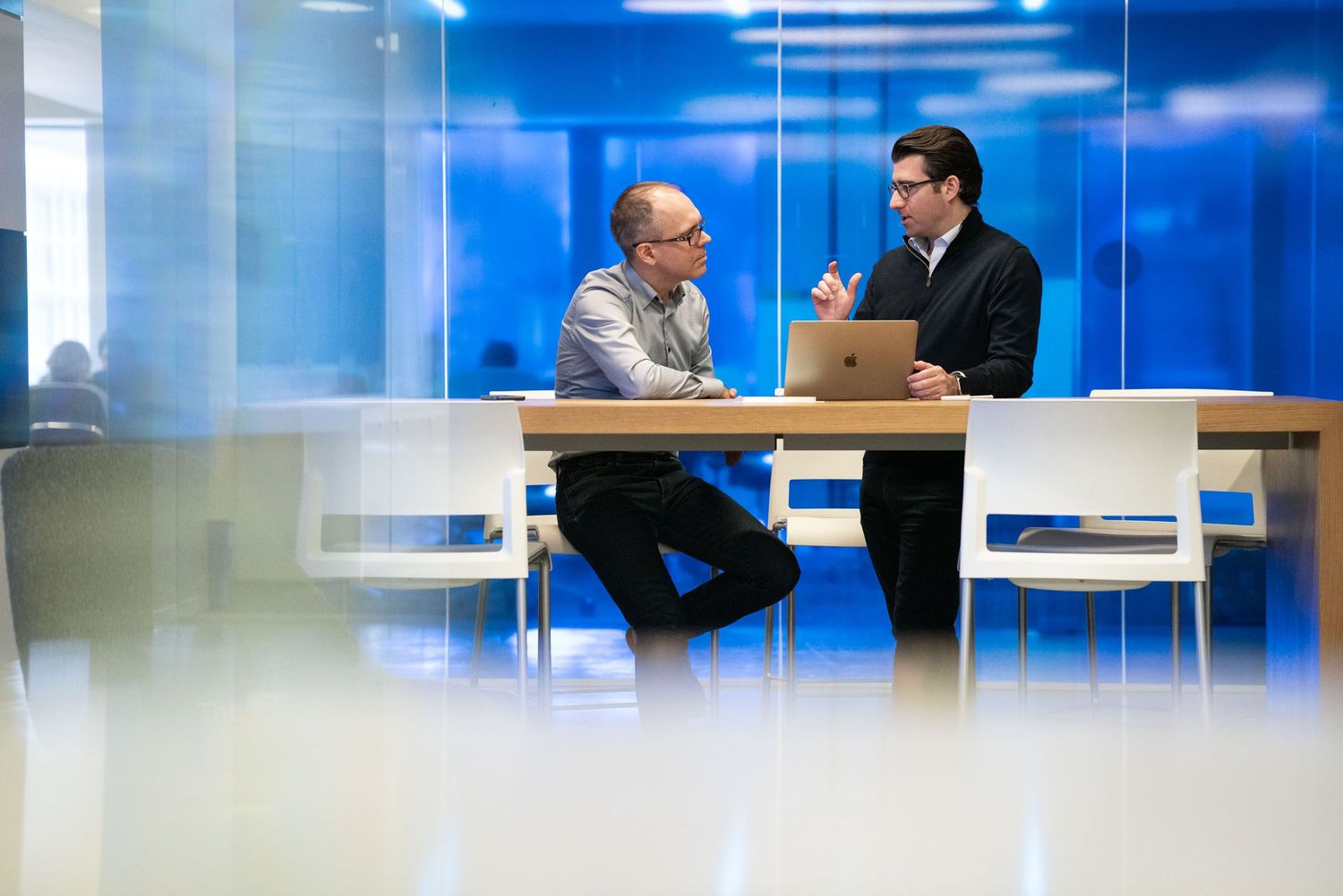 Modern office meeting room with blue walls and natural lighting.