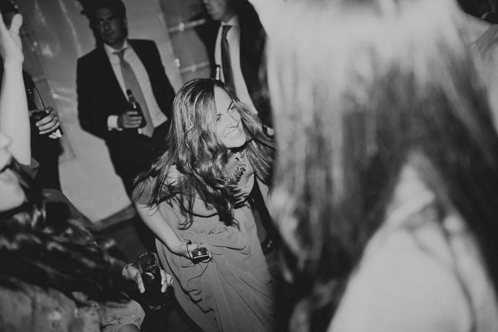 Black and white photo of party guests dancing and celebrating on the dance floor.