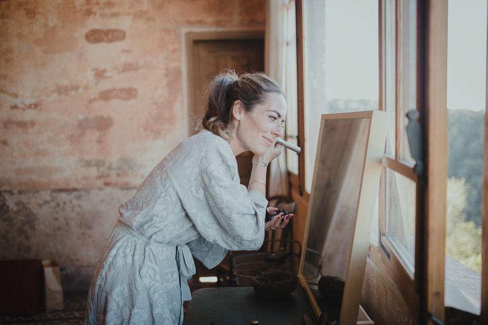 A quiet moment by the window in a rustic room with brick walls.