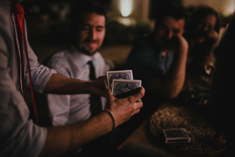 Playing cards being dealt at a dimly lit table during an event.