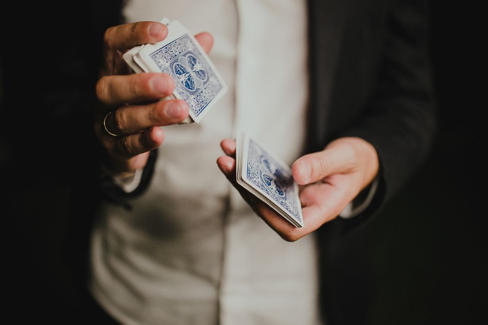 Close-up of hands shuffling playing cards in dramatic lighting.