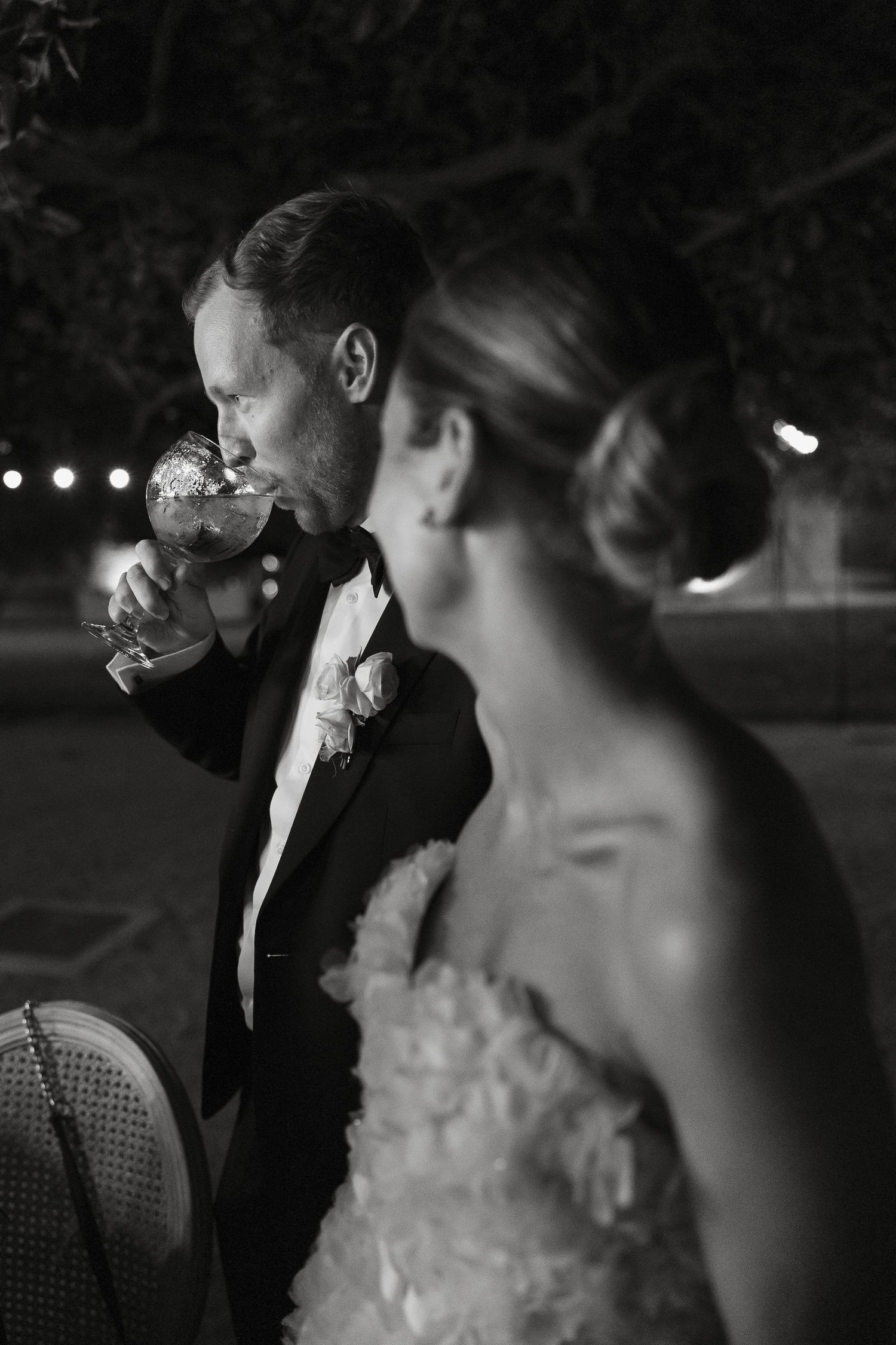 An intimate black and white moment captured during an evening wedding reception.