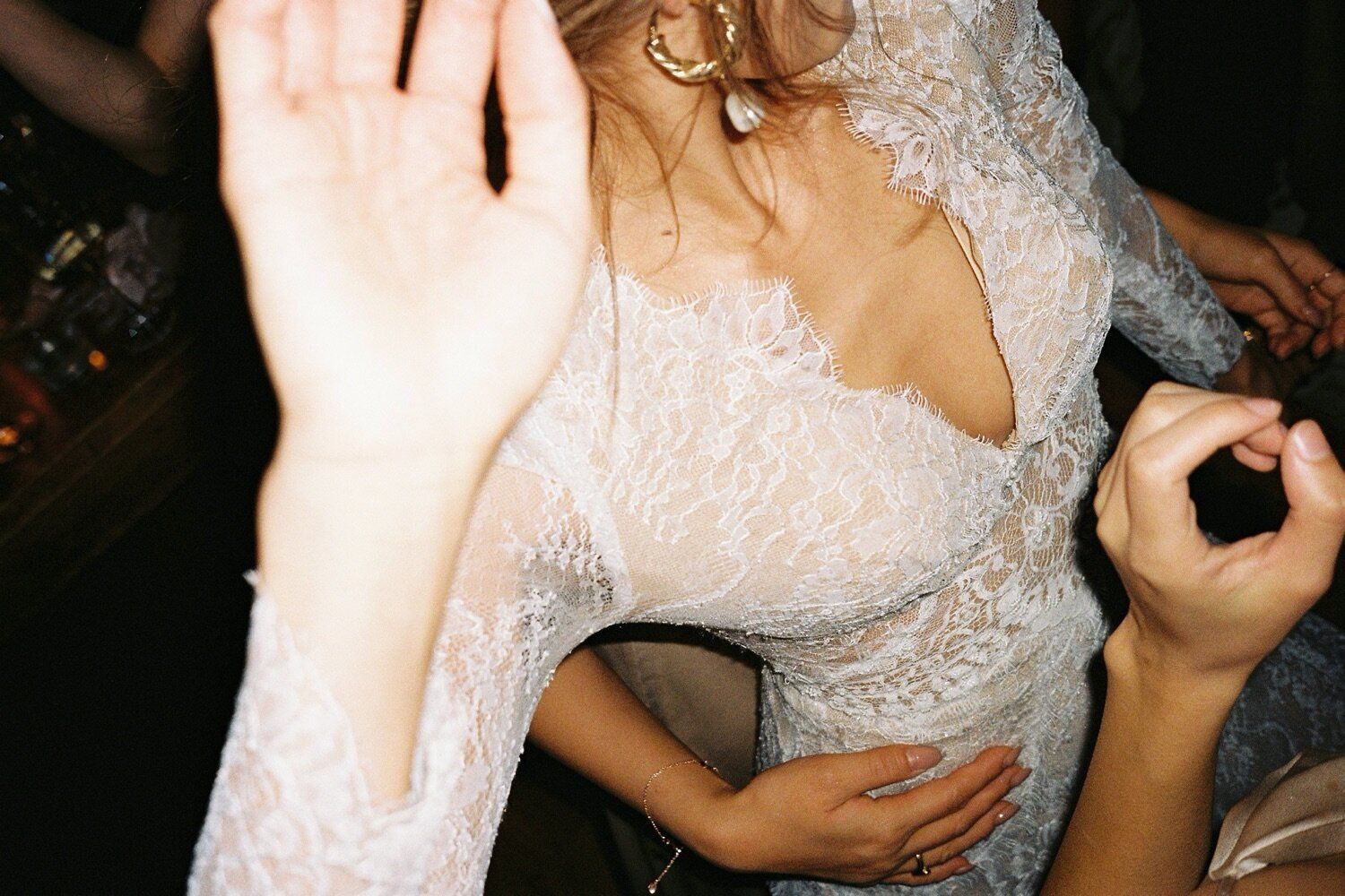 Close-up of bride dancing in lace wedding dress at reception.