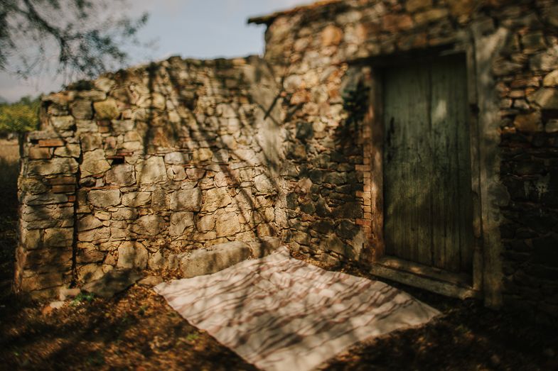 Rustic stone wall with weathered green door in natural lighting.