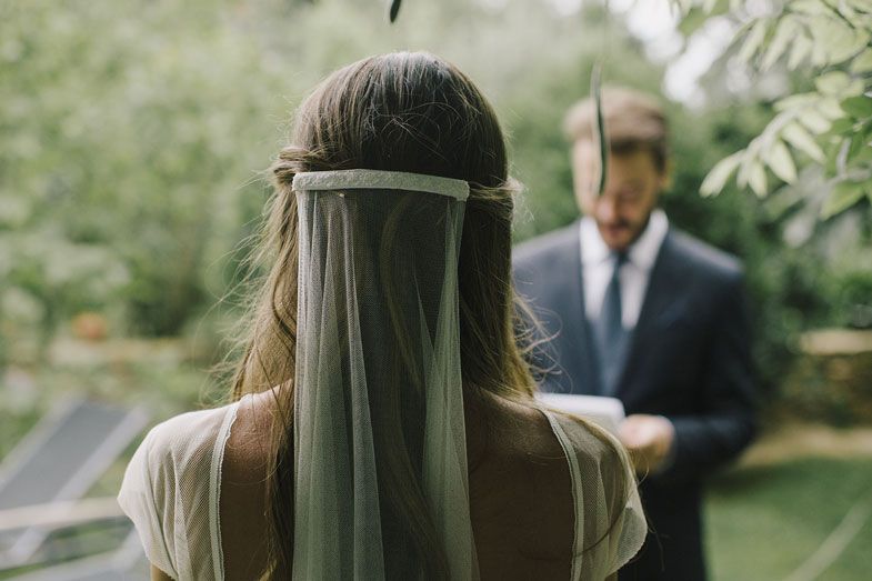 An outdoor wedding scene with green foliage and formal attire.