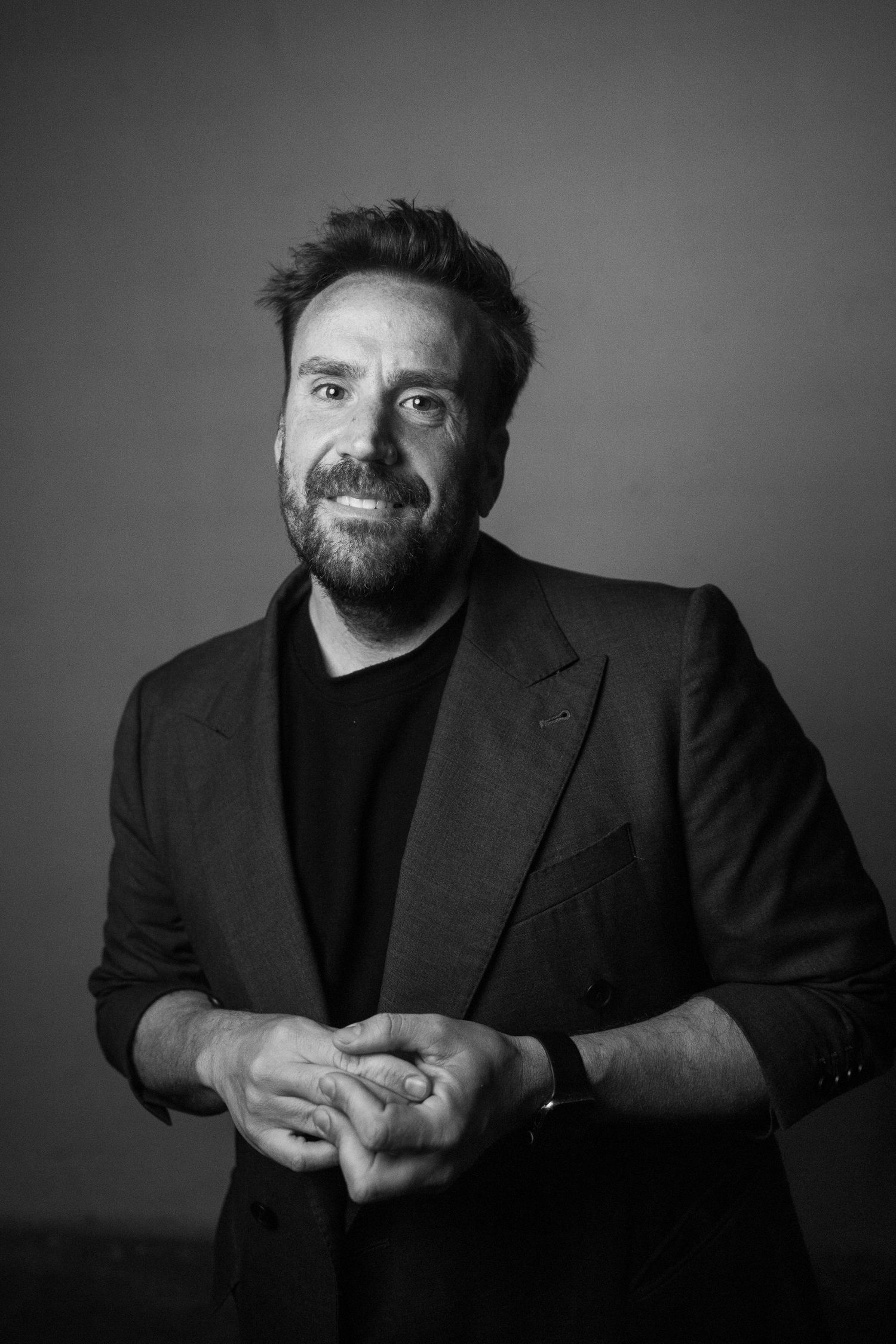 Series of black and white portraits showing expressive poses in dark attire.