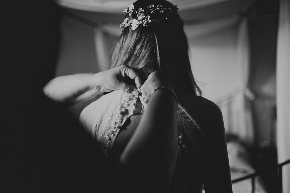 Moody black and white portrait showing a backlit dress and floral headpiece.