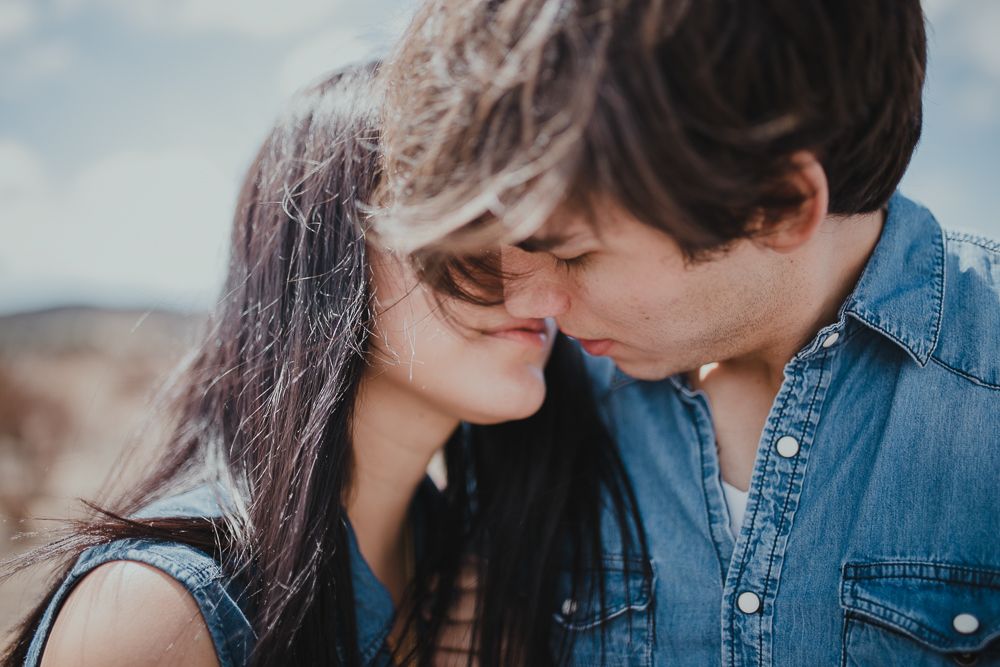 A tender close-up moment between two people wearing blue against a blurred background.