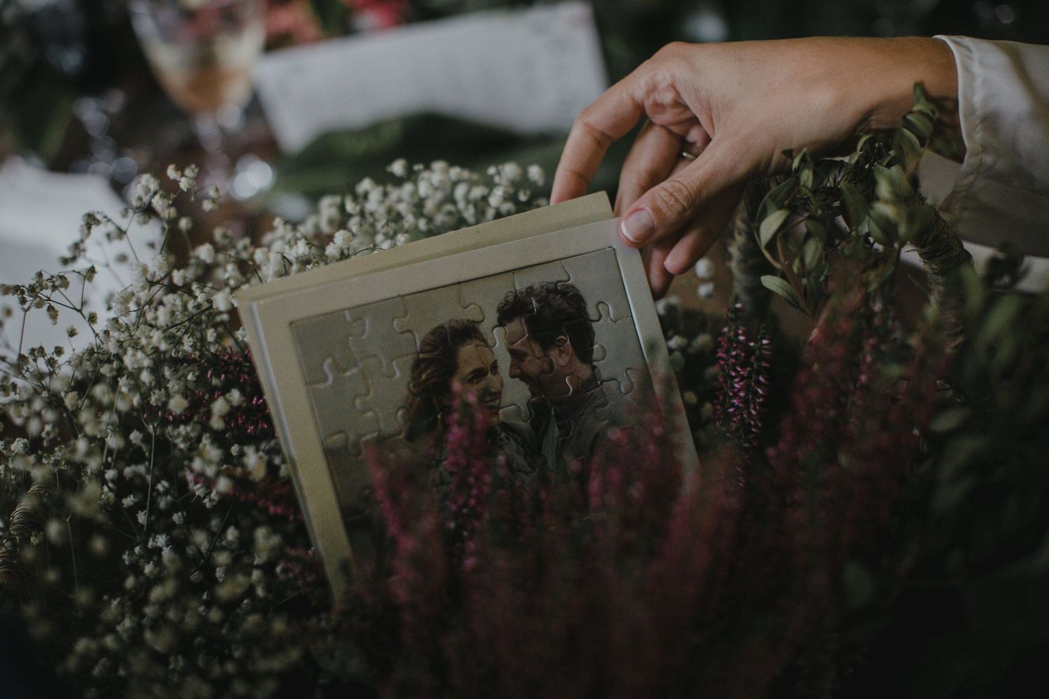 A weathered photograph placed among delicate baby's breath flowers and purple blooms.