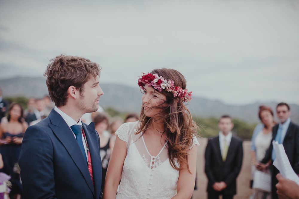 A couple shares an intimate moment during their outdoor wedding ceremony with mountains in the background.
