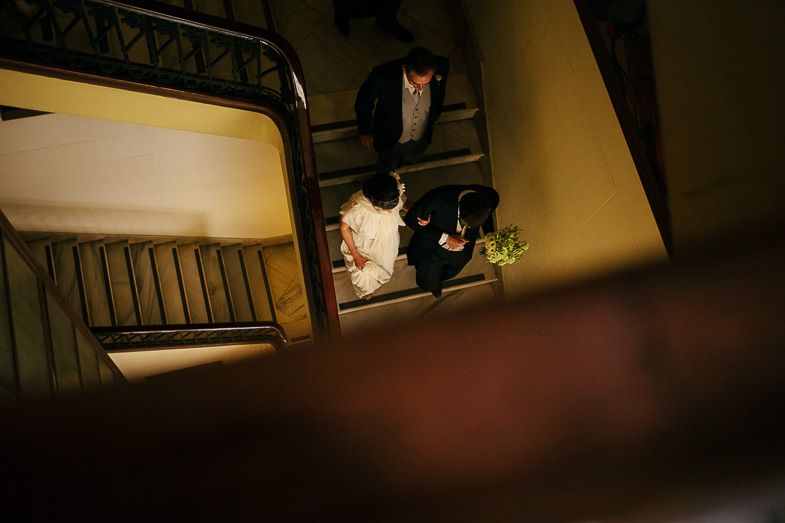 Artistic overhead shot of couple ascending dimly lit staircase.