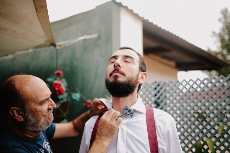 Getting ready scene outdoors with formal attire adjustments.