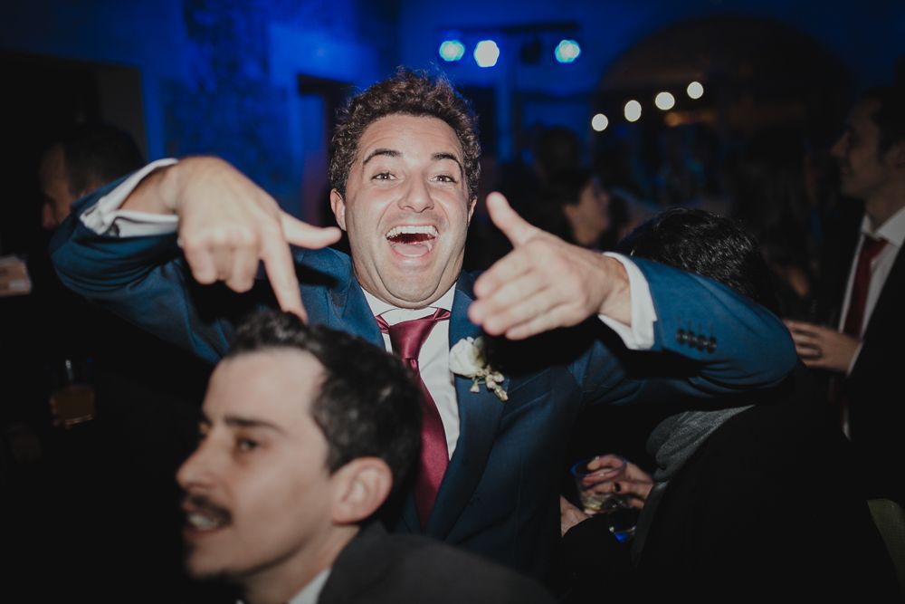 Dancing party guests pose playfully at nighttime celebration.