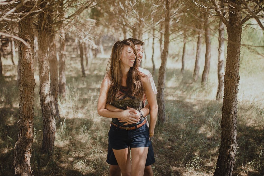 Candid portrait in a sun-dappled forest setting with dreamy lighting.