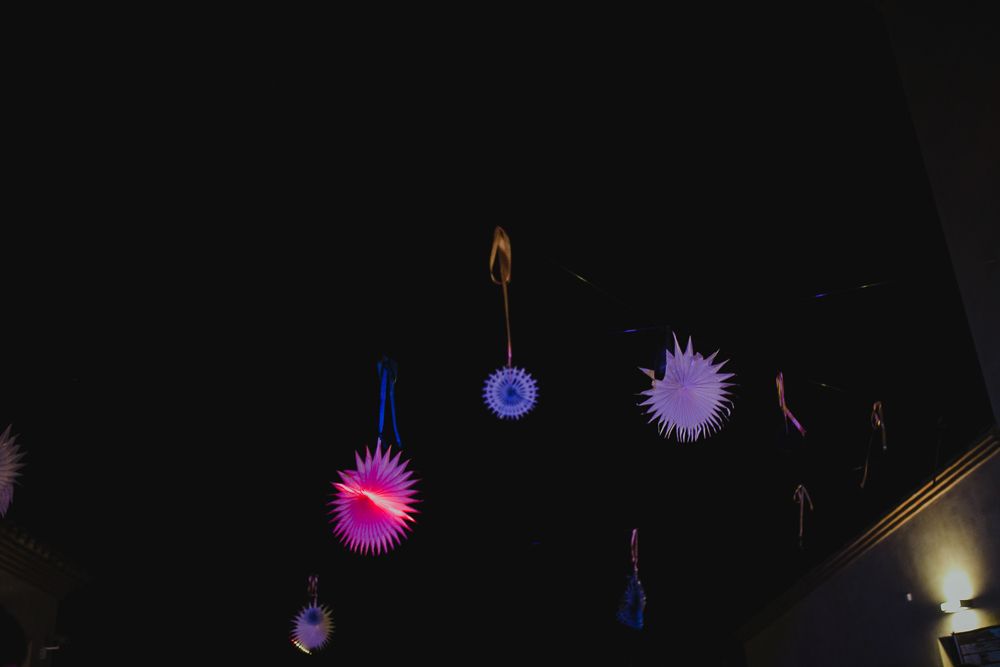 Colorful illuminated decorative lanterns hanging against a dark night sky at an event.