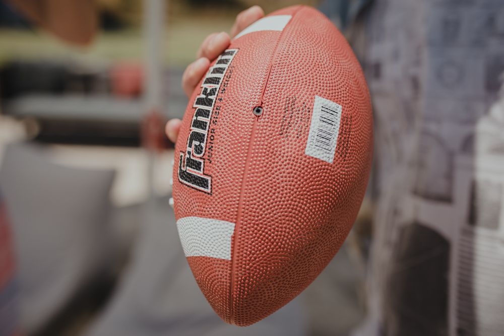 Close-up shot of a regulation football with white stripes and barcode.
