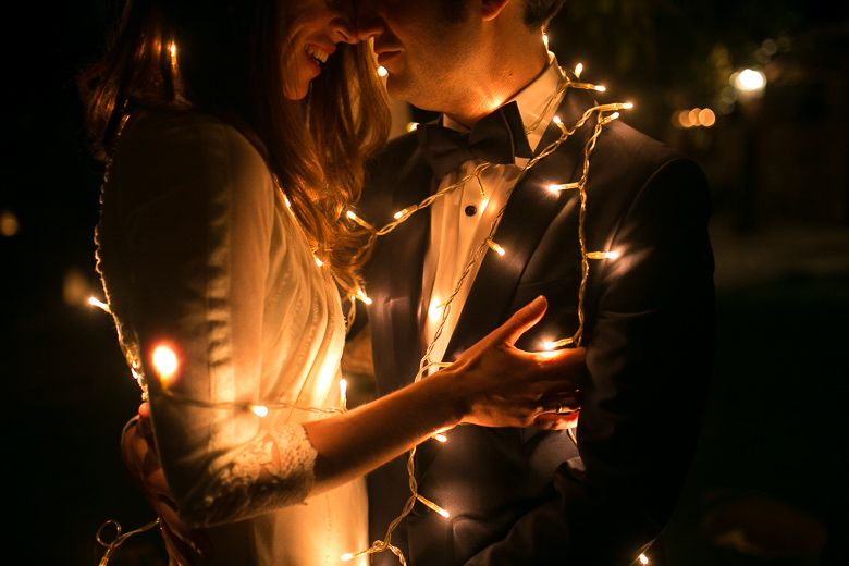 Intimate candlelit moment between couple in formal attire.