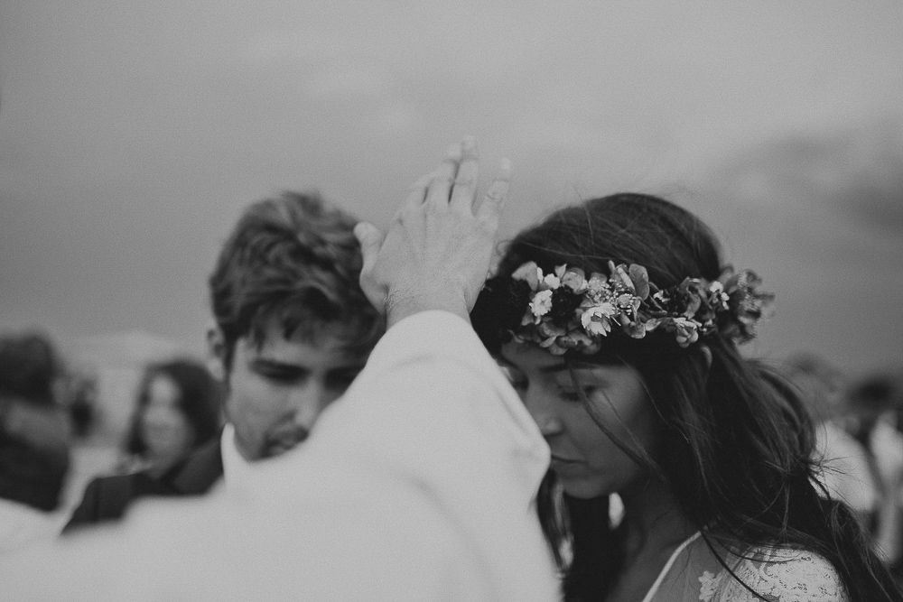 An intimate wedding ceremony moment captured in black and white during a blessing.