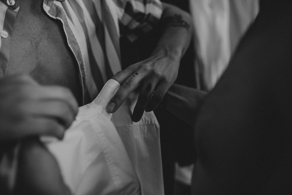 Close-up black and white photo of hands adjusting formal attire.