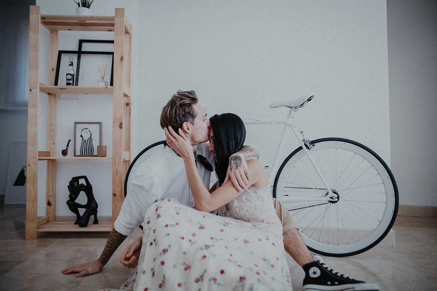 Romantic indoor portrait session featuring vintage decor and white bicycle.