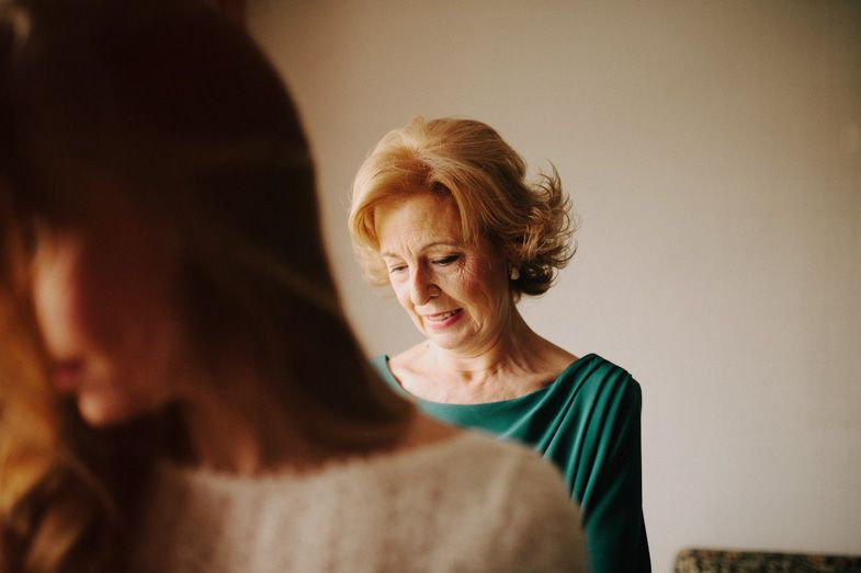 Woman in elegant emerald green dress shown in intimate candid moment.