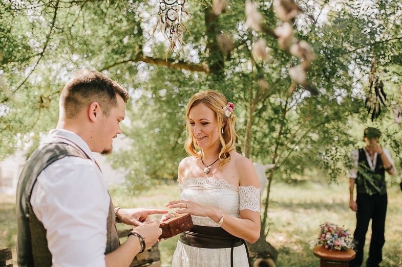 A couple exchanging rings during their outdoor garden wedding ceremony.