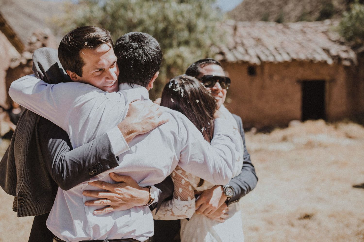 Emotional embraces shared between wedding attendees during outdoor celebration.