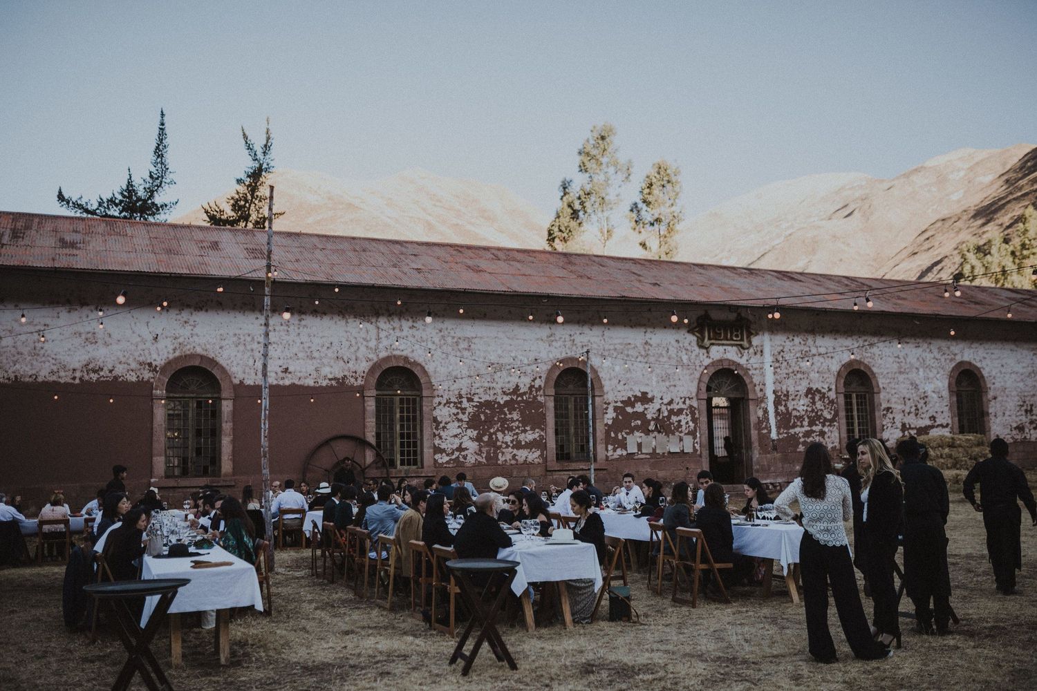 An outdoor reception setup with tables and chairs against a historic building facade.