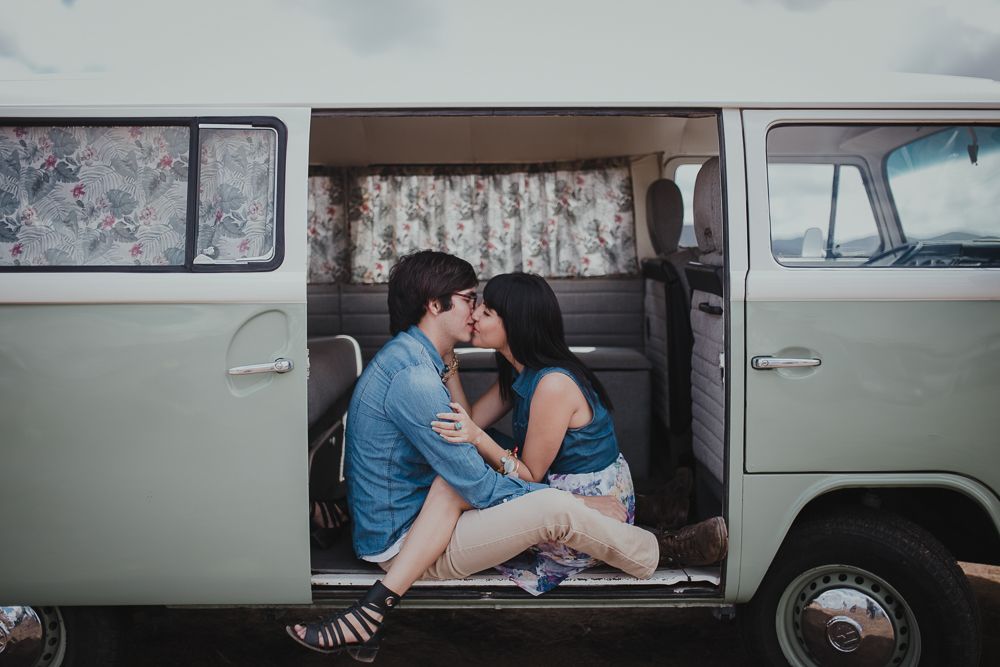 Vintage mint green VW van parked in desert setting with side door open.