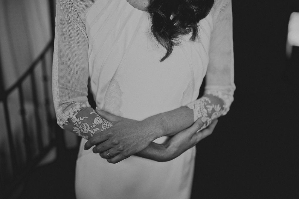 Black and white detail shot of wedding dress with lace sleeves and fitted bodice.