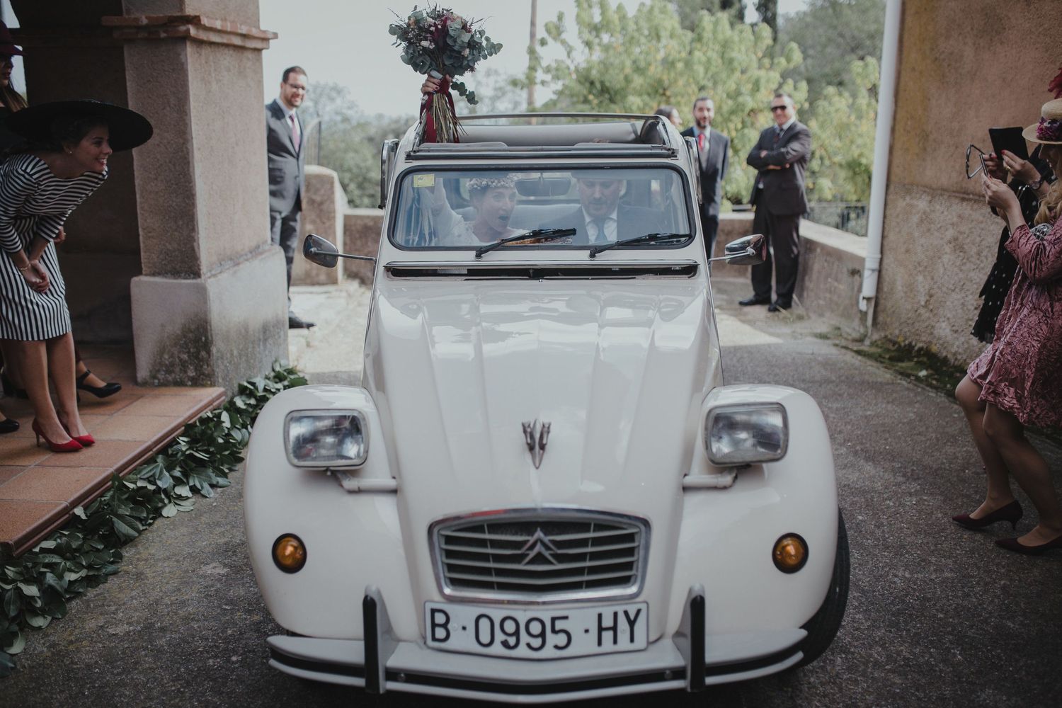 Classic white Citroen 2CV car decorated for wedding transportation.
