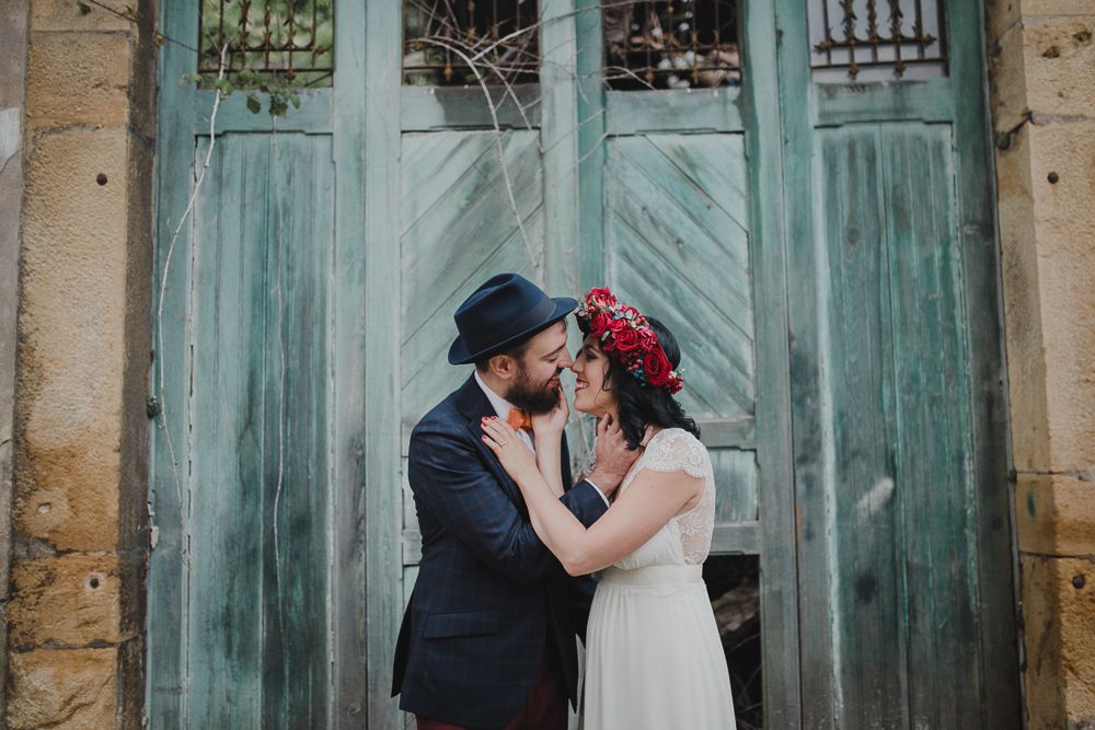 Romantic wedding portrait in front of a distressed turquoise door with vintage styling.