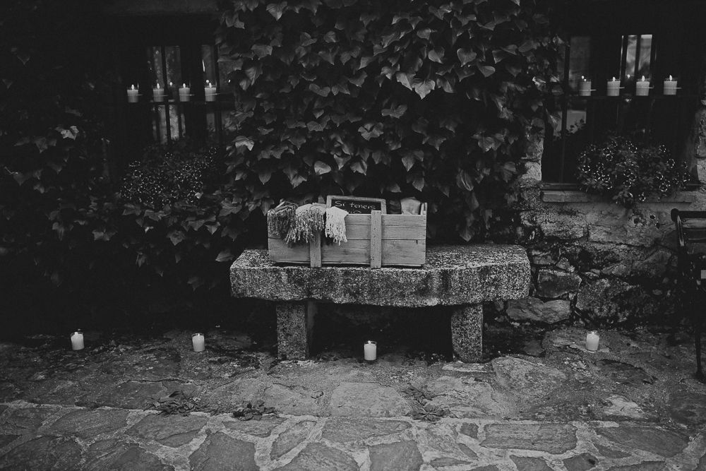 A rustic stone bench decorated with candles creates a romantic atmosphere.