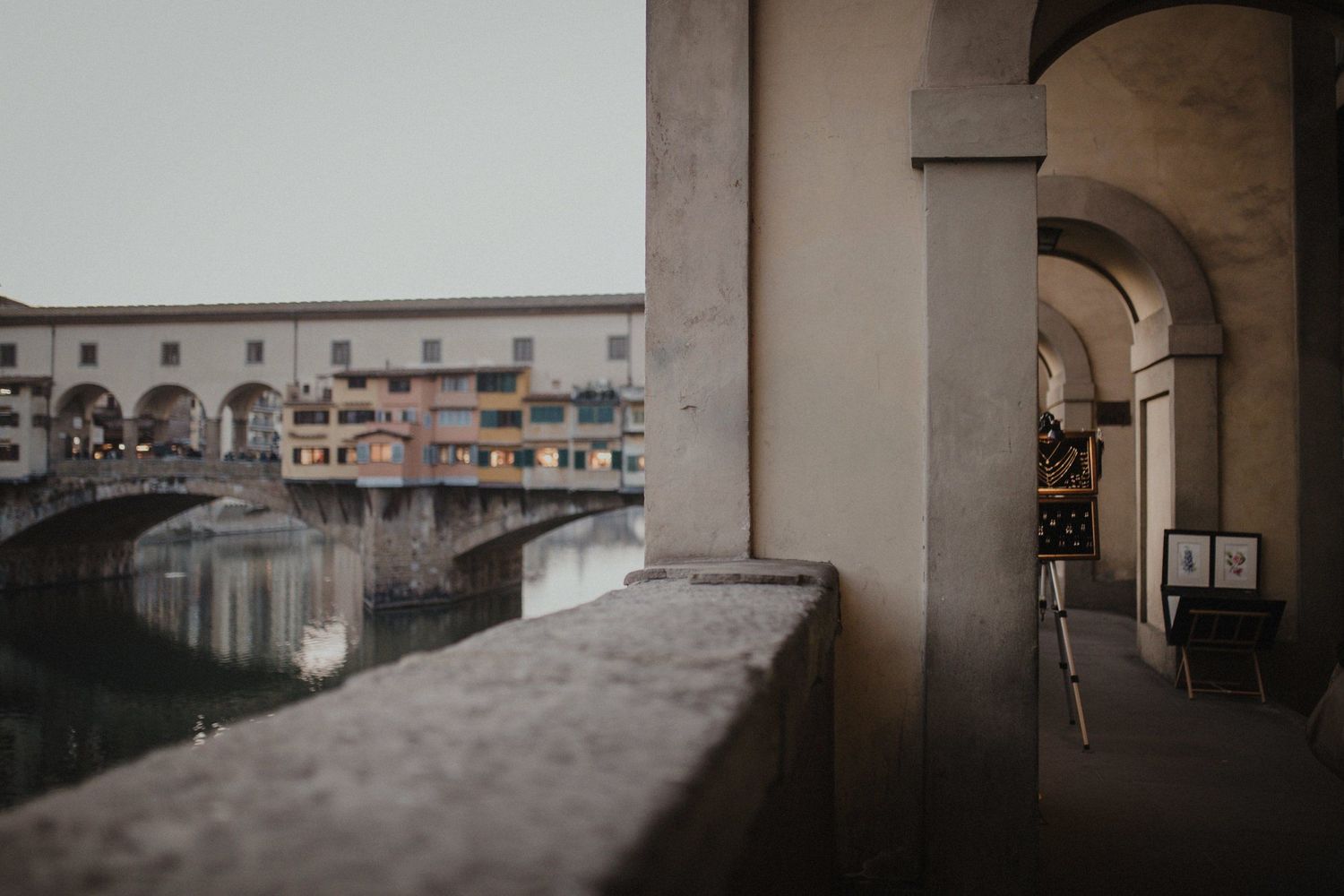 View of Ponte Vecchio bridge through stone archway in Florence, Italy.