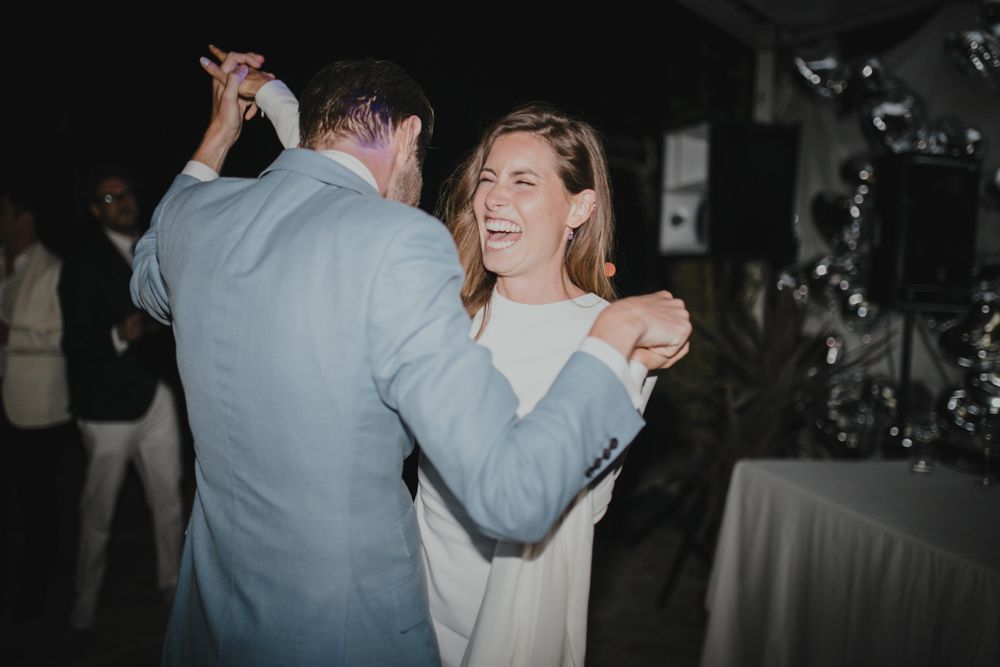 A couple shares a dance moment at an indoor reception venue.
