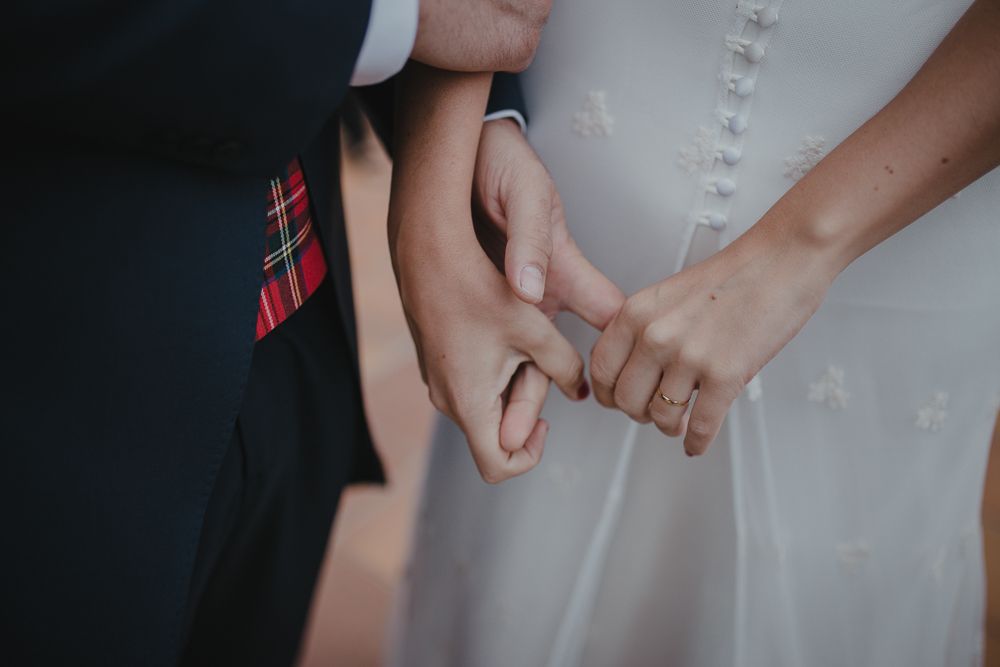 Close-up detail shot of hands holding during a wedding ceremony.