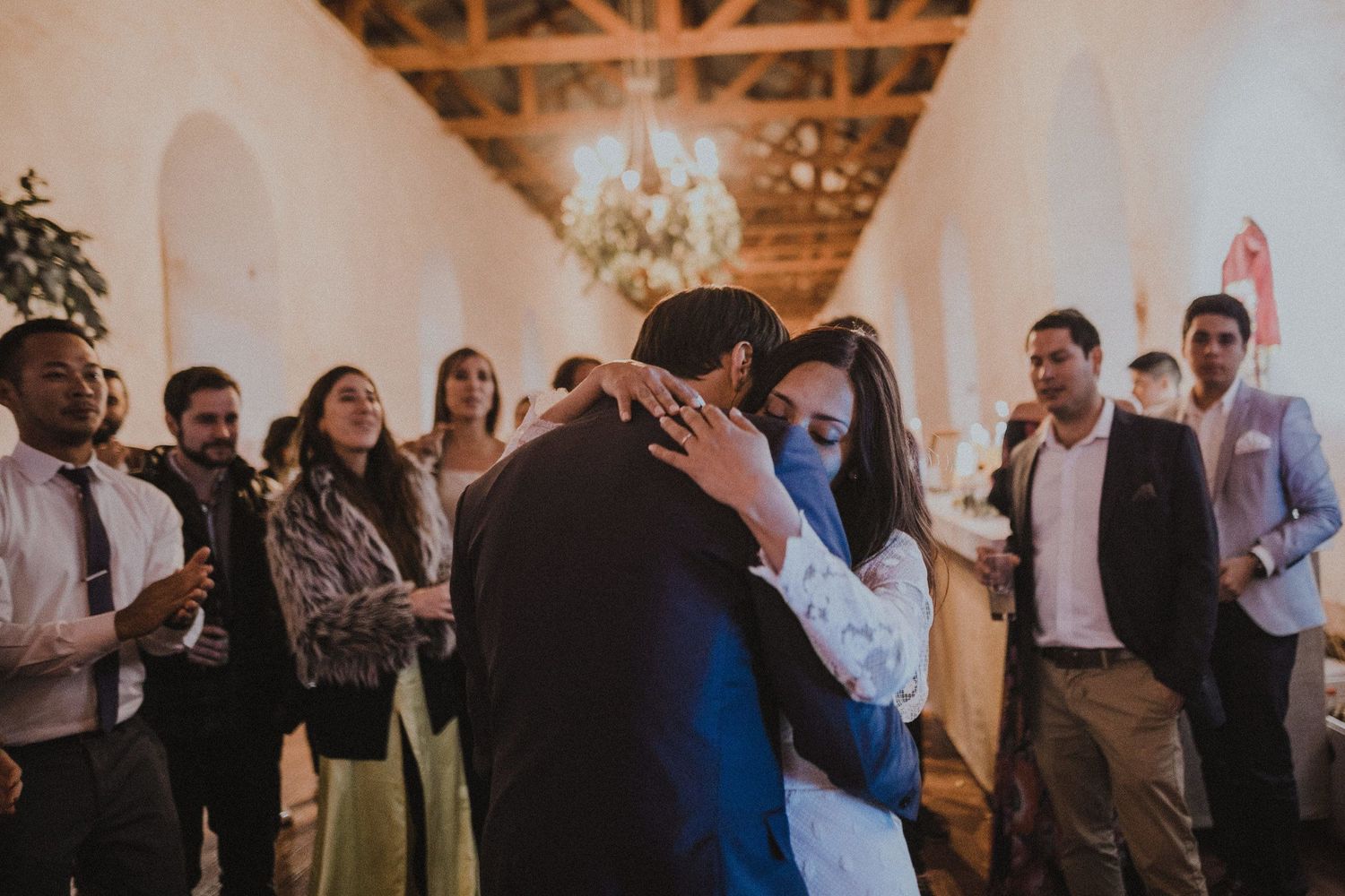 Romantic dance moment between couple while guests look on in elegant indoor venue.