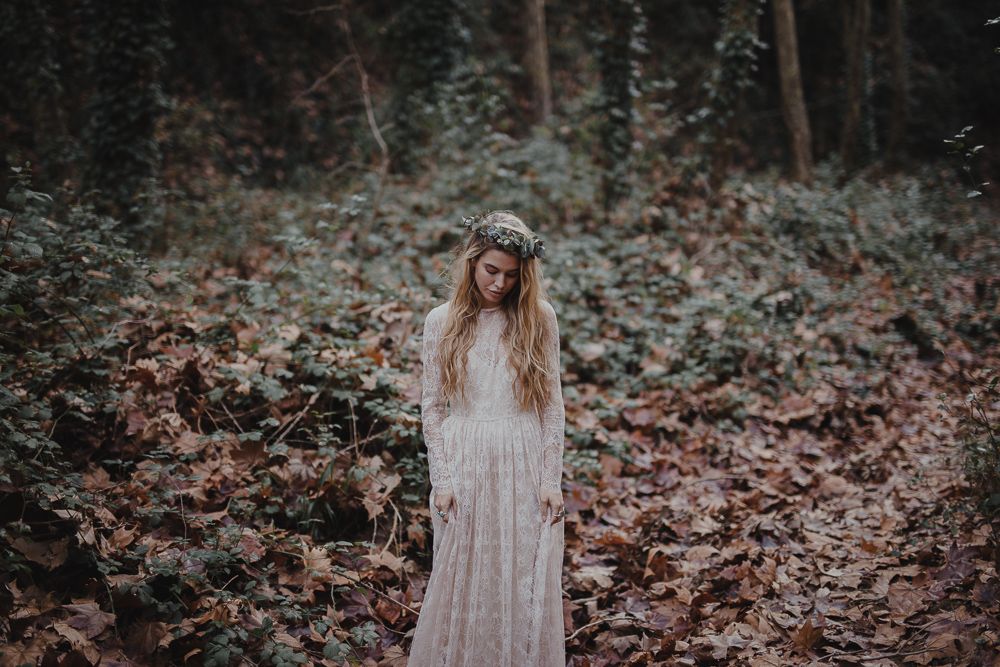 A dreamy forest portrait featuring a long white lace dress and floral crown.