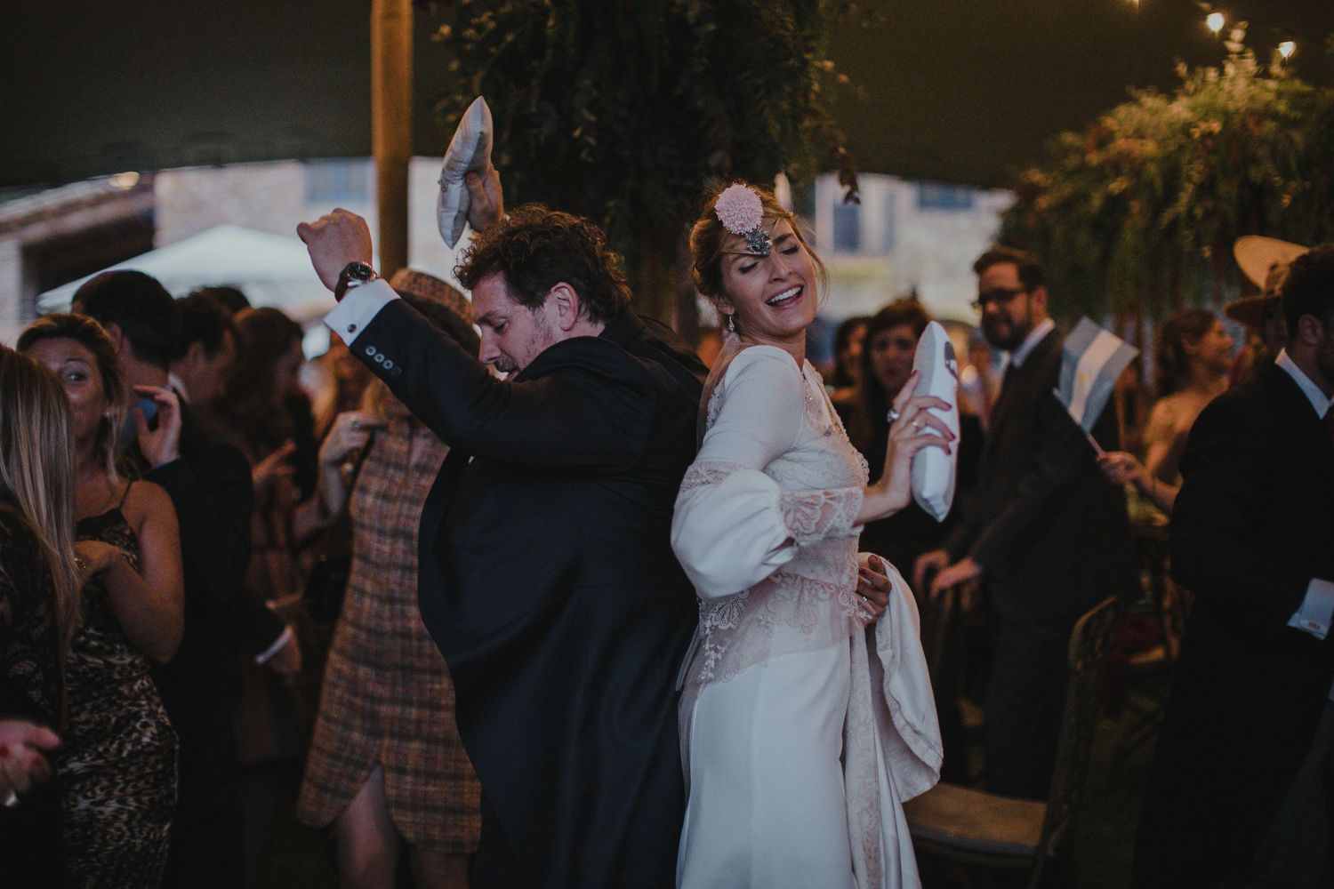 Dancing couples celebrate at an evening outdoor wedding reception.